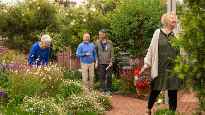 Four people enjoy a garden at The Cottage Homes Ascot Park